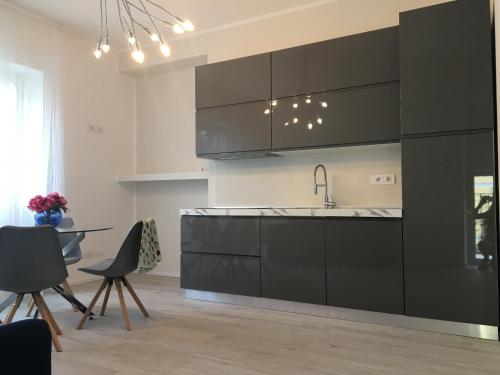 a kitchen with black cabinets and a table and chairs at Villa Romantika in Arco
