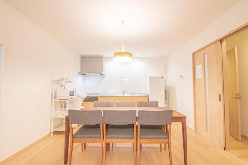 uma sala com mesa e cadeiras e uma cozinha em Ecru Haruyoshi Logement em Fukuoka