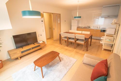 a living room with a television and a table at Ecru Haruyoshi Logement in Fukuoka