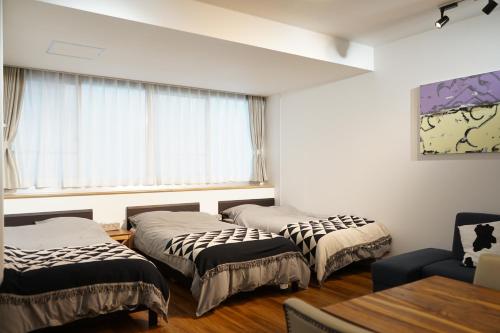 Duas camas num quarto com uma janela em Culinary Bed&Art2 403 em Hamamatsu