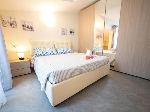 une chambre avec un grand lit blanc et un miroir dans l'établissement Parco del Mare - Relax near the sea and city centre, à Borghetto Santo Spirito