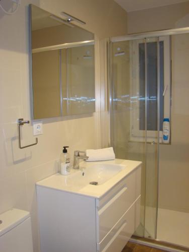 uma casa de banho com um lavatório branco e um chuveiro em Apartamentos La Pereda Santander- Estudio E1 em Santander