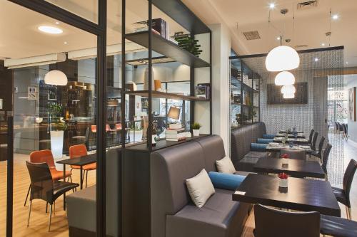 a restaurant with several tables and chairs and tablesearcher at Silken Juan de Austria in Valladolid