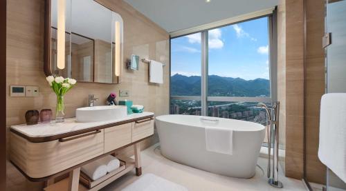 a bathroom with a tub and a sink and a window at InterContinental Chongqing Raffles City by IHG in Chongqing