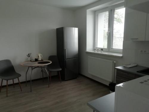 een keuken met een kleine tafel en een koelkast bij Apartmány Stdaniela in Bohumín