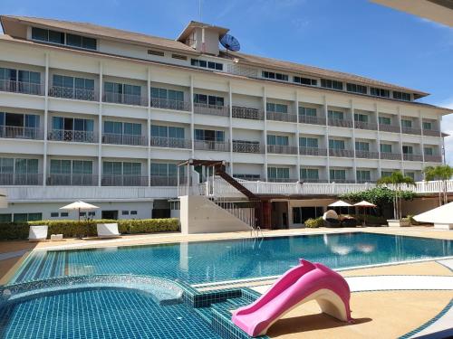 a large hotel with a swimming pool with pink high heels at Swan Lake Hotel Sattahip in Sattahip