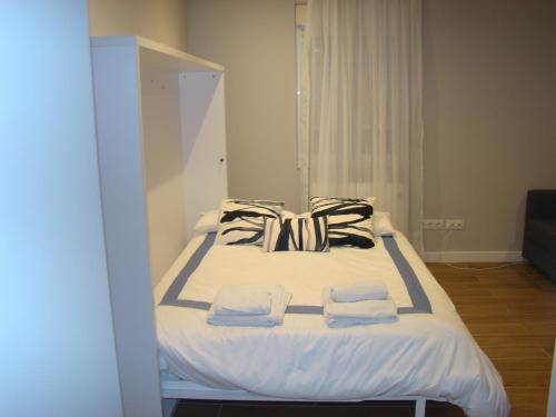 a bed in a room with two towels on it at Apartamentos LA PEREDA SANTANDER in Santander