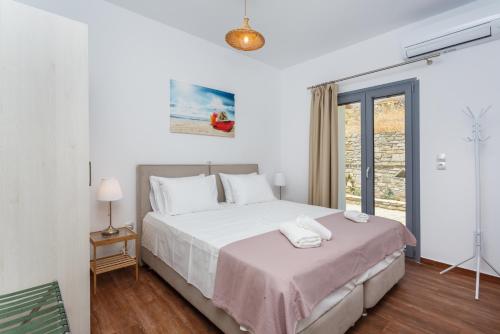 - une chambre avec un grand lit blanc et une fenêtre dans l'établissement Villa Jessy 150m² with Full Privacy, à Parikia
