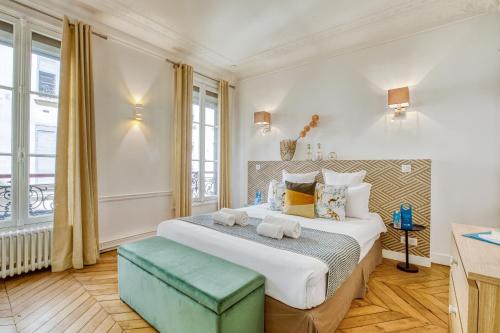 une chambre avec un grand lit et une fenêtre dans l'établissement Sweett - Atelier Napoleon, à Paris