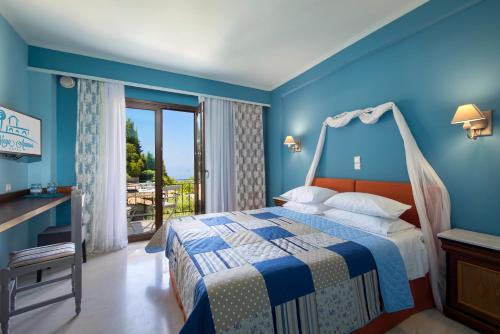 a blue bedroom with a bed and a balcony at MEGA AMMOS HOTEL in Syvota