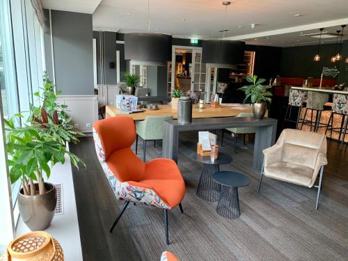 a room with a table and chairs and a dining room at Tulip Inn Leiden Centre in Leiden