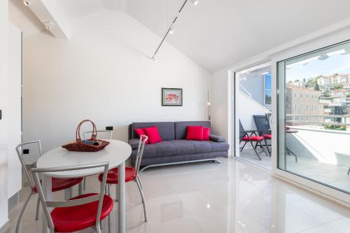 a living room with a couch and a table and chairs at Apartments Marando in Dubrovnik