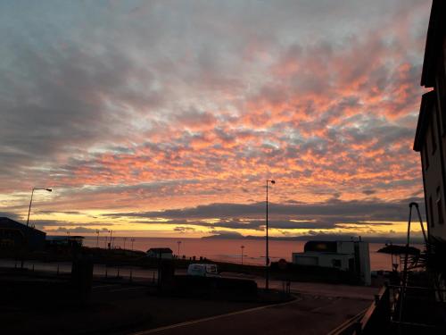 un coucher de soleil sur l'océan avec un ciel nuageux dans l'établissement Ocean Bliss, à Bundoran