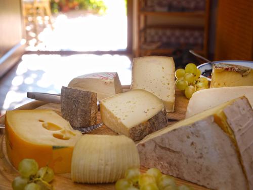 a bunch of cheese and grapes on a cutting board at Hotel Al Fiume in Tegna