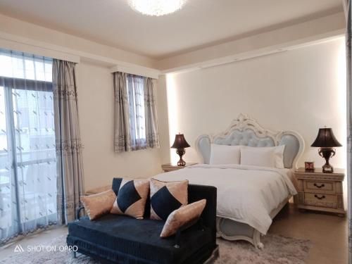 um quarto branco com uma cama e um sofá em 一中太陽綠墅 em Taichung