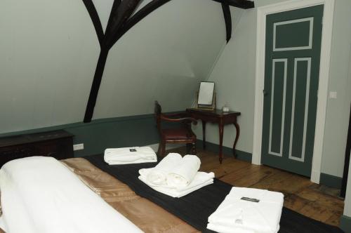 een slaapkamer met een bed met handdoeken erop bij Bed en kerk monumentale 2 slaapkamer woning in Hoorn