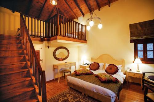 ein Schlafzimmer mit einem großen Bett und einer Treppe in der Unterkunft Hotel Athina in Elati Zagoria