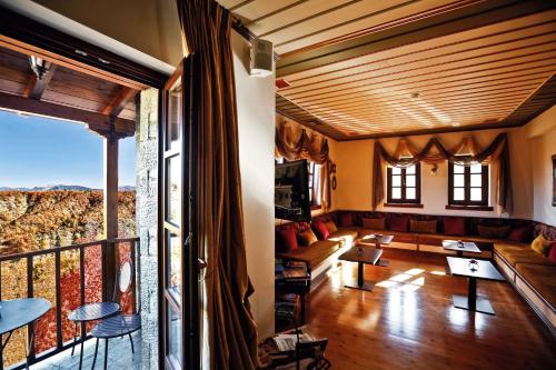 a living room with a couch and a balcony at Hotel Athina in Elati Zagori