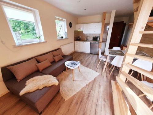 a living room with a couch and a kitchen at Noclegi u Gabrysi in Kościelisko