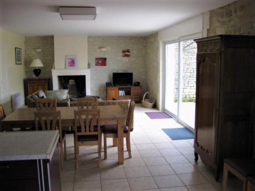 L'En Haut des Vignes في Mérignac: مطبخ وغرفة معيشة مع طاولة وكراسي