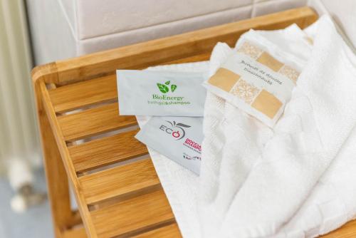 un cesto con asciugamani e certificati su un letto di Residence Le Corniole ad Arezzo