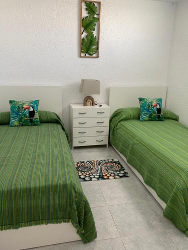 sypialnia z 2 łóżkami i komodą w obiekcie Cozy apartment near the sea w Alicante