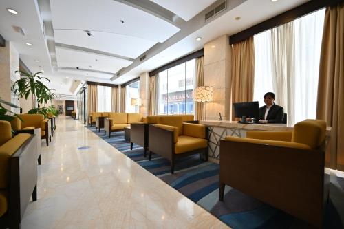 a man sitting at a desk in a waiting room at Harbour Suites Hotel in Manama