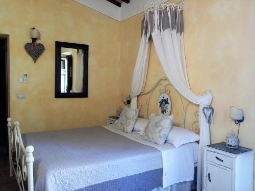 a bedroom with a white bed with a canopy at Agriturismo Il Casalino in Pienza