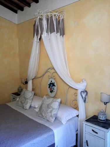 a bedroom with a bed with curtains on it at Agriturismo Il Casalino in Pienza