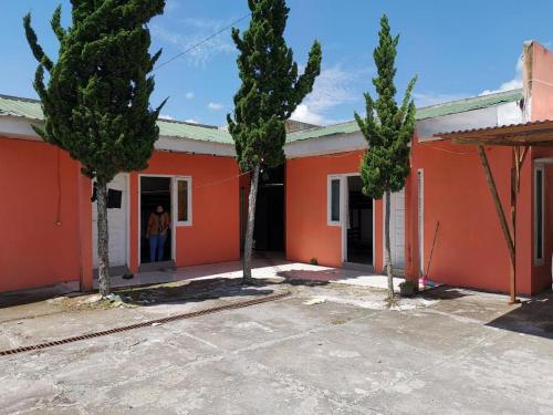 uma casa laranja com árvores em frente em QQ HOMESTAY em Takengon