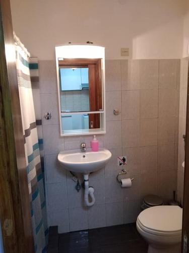 a bathroom with a sink and a toilet and a mirror at Ξενώνας Το Πέτρινο 2 in Keramídhion