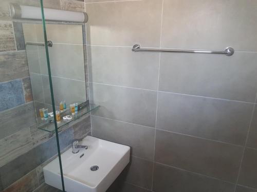 a bathroom with a sink and a glass shower at Vrahos in Kardamaina