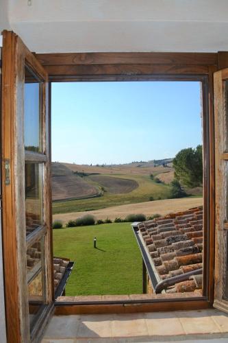 an open window with a view of a field at Agriturismo Il Casalino in Pienza