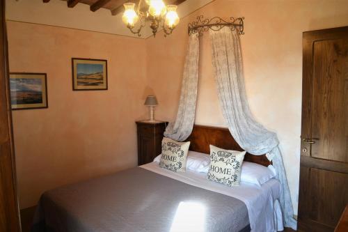 a bedroom with a bed with a canopy at Agriturismo Il Casalino in Pienza