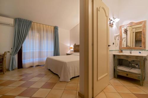 a hotel room with a bed and a sink at Porto Giunco Residence in Villasimius