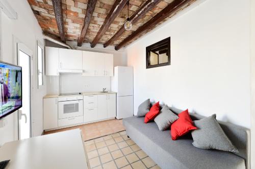 uma sala de estar com um sofá cinzento e almofadas vermelhas em Design Club Reus em Reus