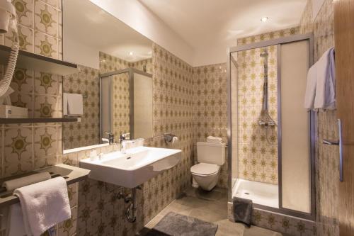 a bathroom with a sink and a toilet and a shower at Hotel Hafele in Kaunertal