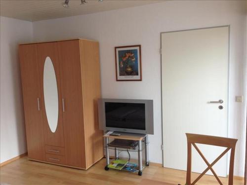 a living room with a television and a cabinet at Ferienwohnung Mühlbach in Isny im Allgäu