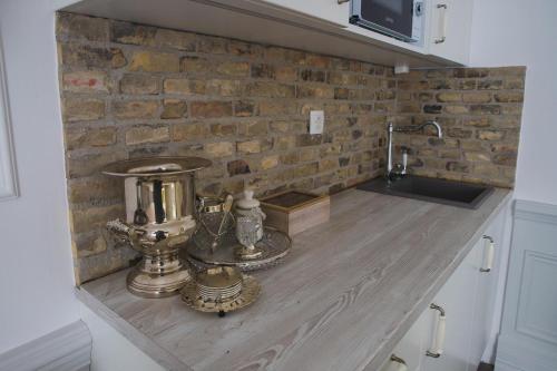 a kitchen counter with a mixer and a brick wall at BAB-LAK Apartman in Kisvárda