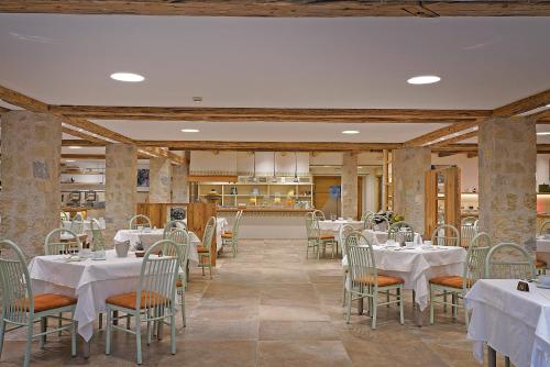 une salle à manger avec des tables et des chaises blanches dans l'établissement Hotel Caravel, à Limone sul Garda