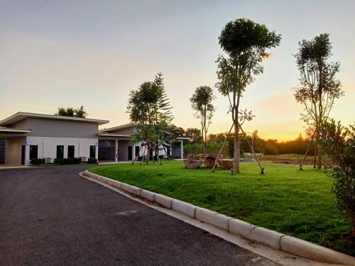 a house with a yard with palm trees at Rock Resort in Ratchaburi