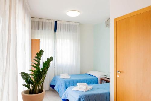 a room with two blue beds and a plant at Residence Le Corniole in Arezzo