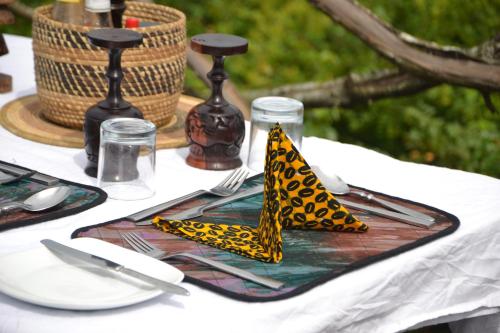 a table with a plate with a napkin with a leopard napkin at Topi Lodge in Queen Elizabeth National Park