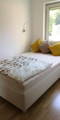 a white bed in a room with a window at Seeappartement Ingrid in Bodensdorf
