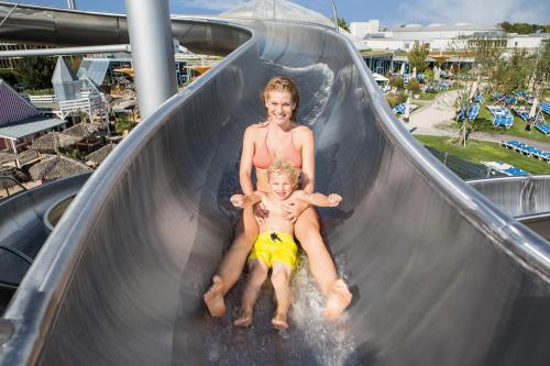 two young boys riding down a slide at an amusement park at Familienhotel nahe der Therme Erding in Erding