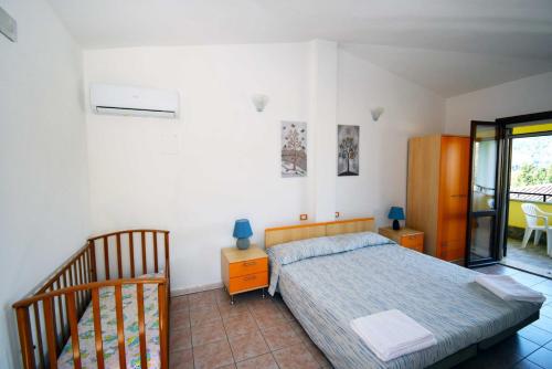 a bedroom with a bed and a sliding glass door at La Corte Degli Ulivi in Cardedu