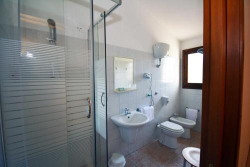 a bathroom with a toilet and a sink and a shower at La Corte Degli Ulivi in Cardedu