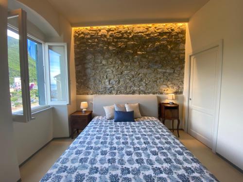 a bedroom with a bed and a stone wall at Ca de Marge in Corniglia