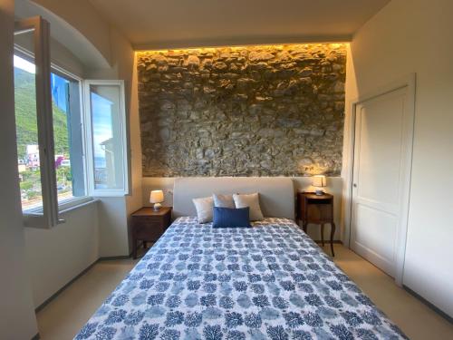 a bedroom with a bed and a stone wall at Cà de Marge in Corniglia