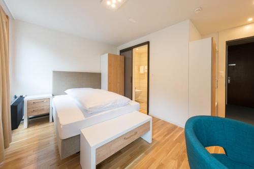 a bedroom with a bed and a blue couch at B&B Hotel Mattli Übernachtung Frühstück in Morschach